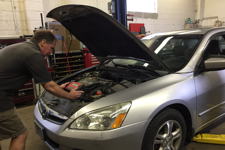 Ken Gardner using the computer diagnostic tool to properly repair this car.